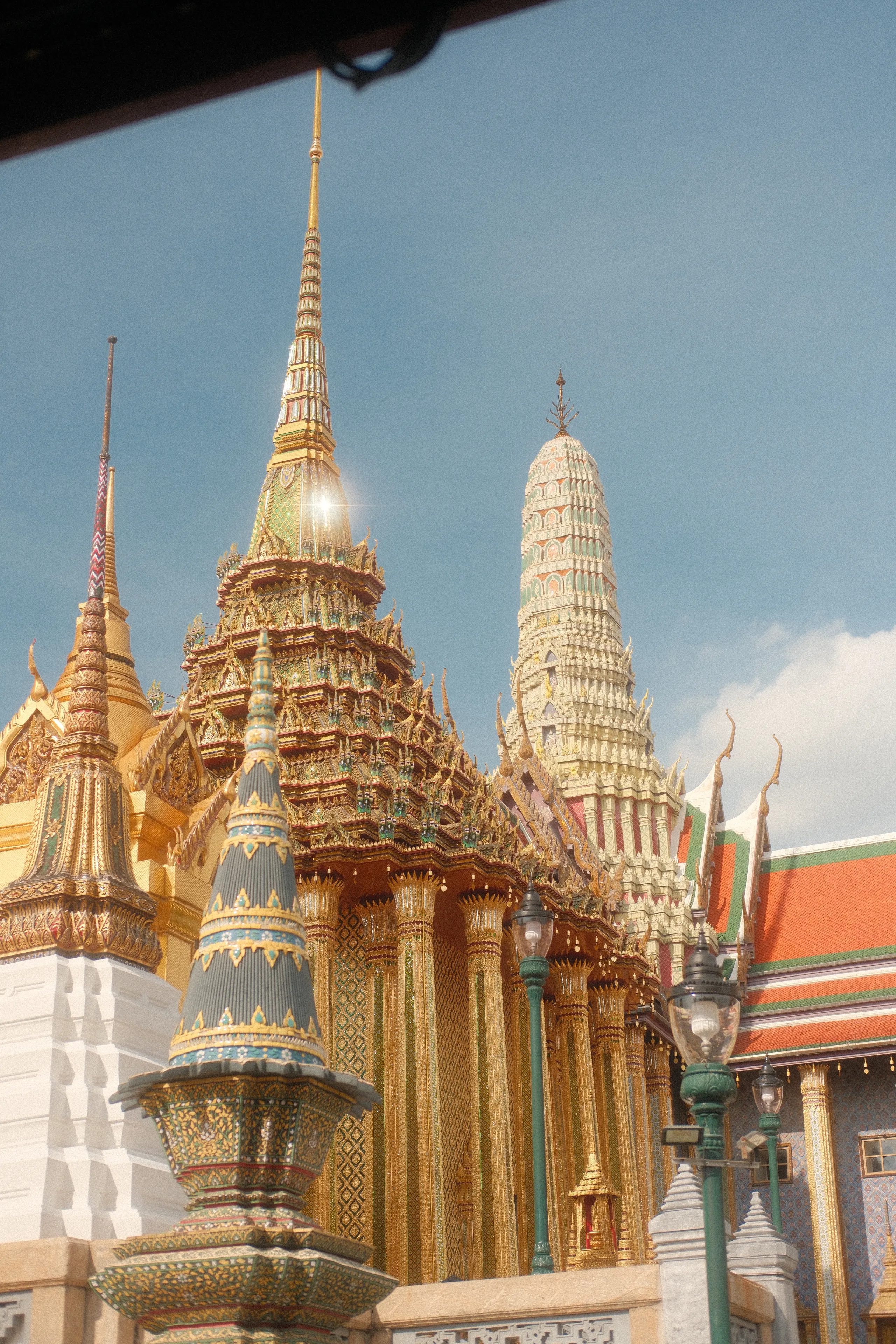 Gilded spires at the Grand Palace against a blue sky
