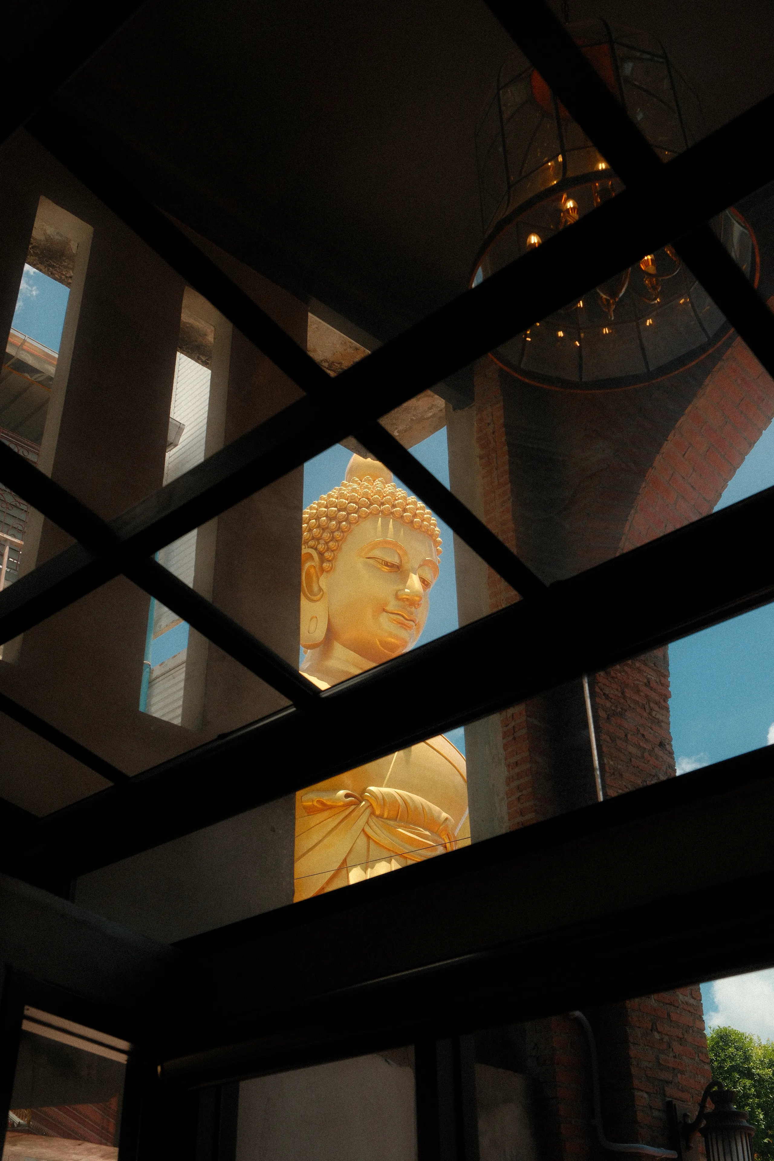 The giant golden Buddha at Wat Paknam seen through a glass roof