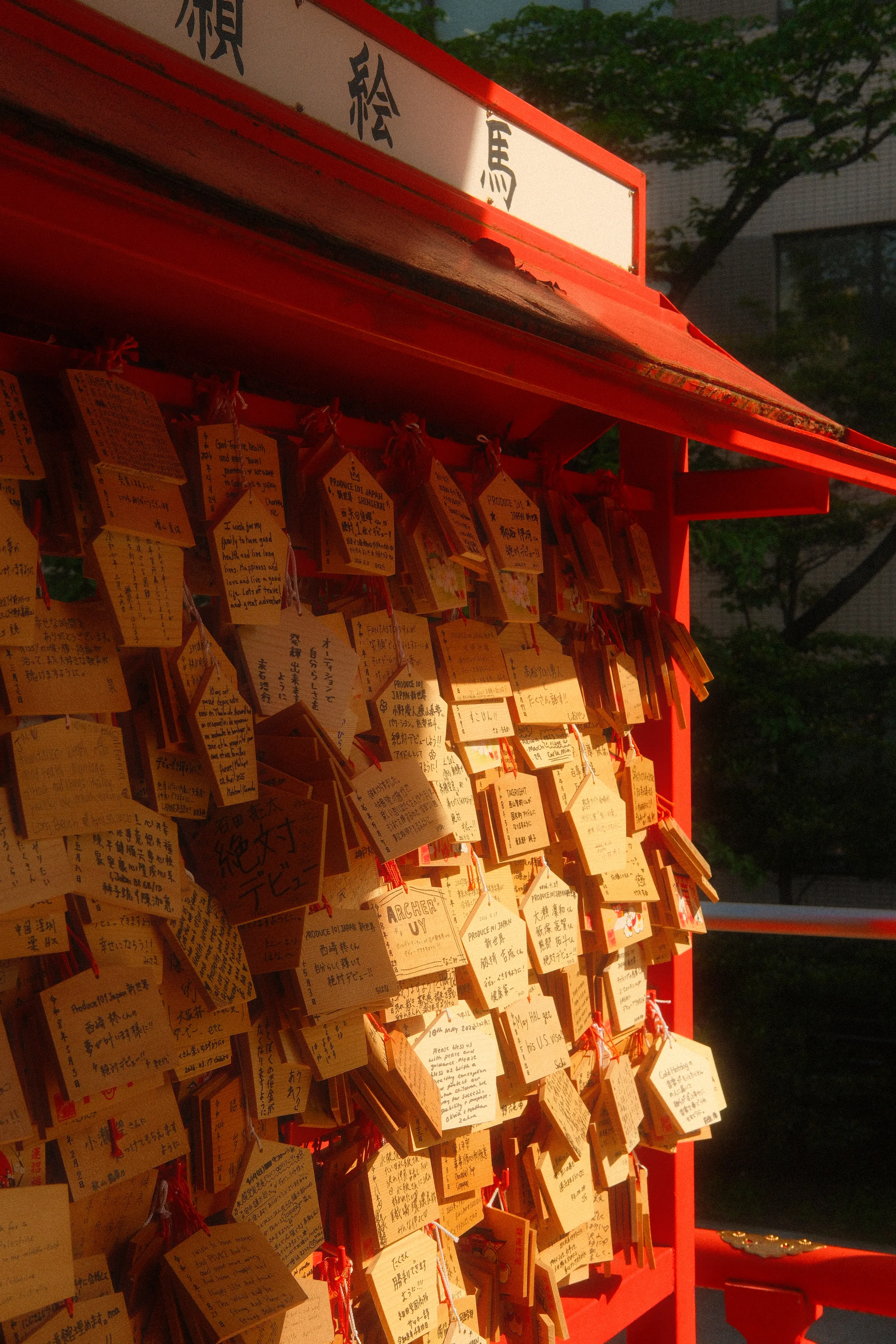 Wooden ema prayer plaques hanging at a red shrine stand