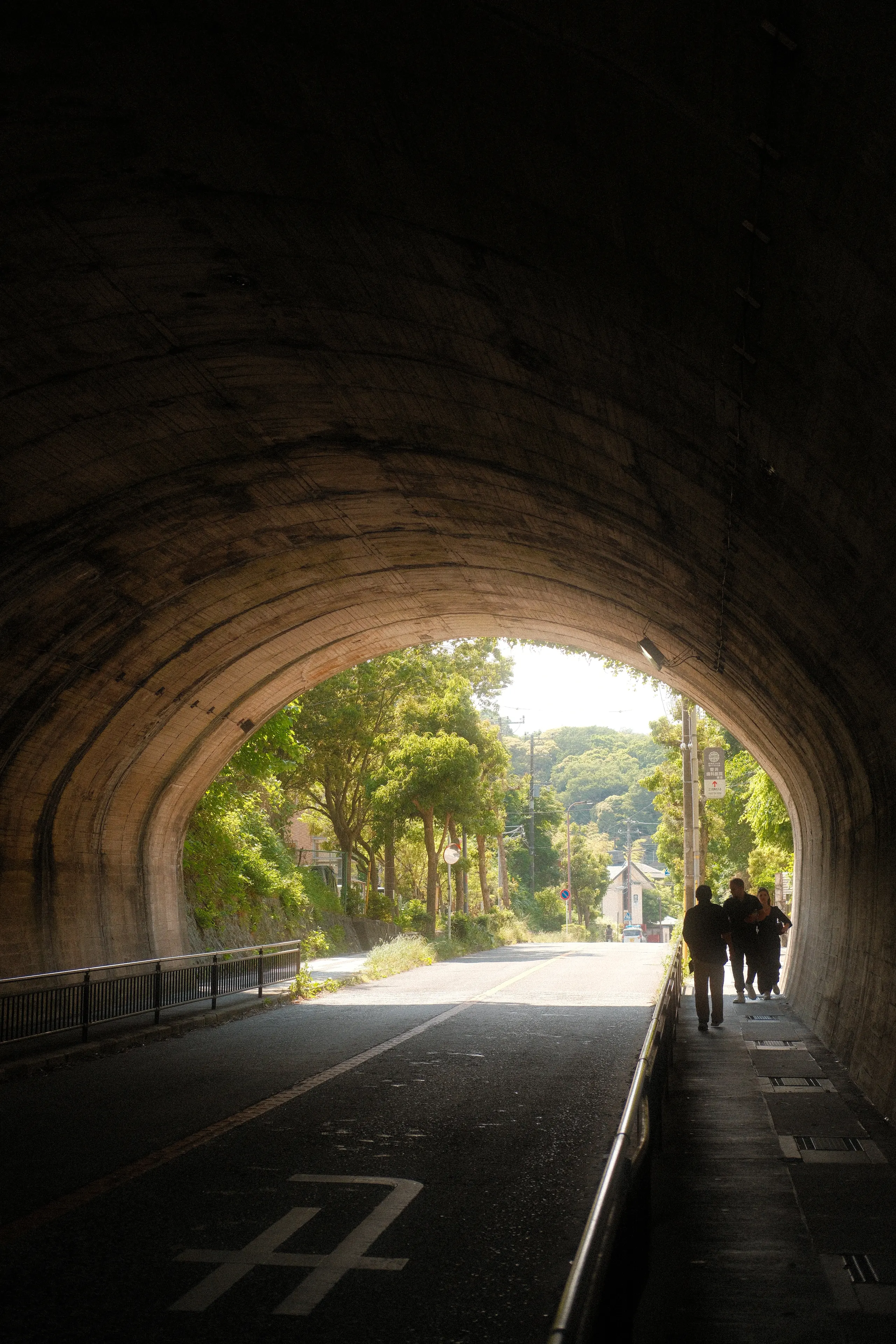 A road tunnel opening onto green hills in Kamakura