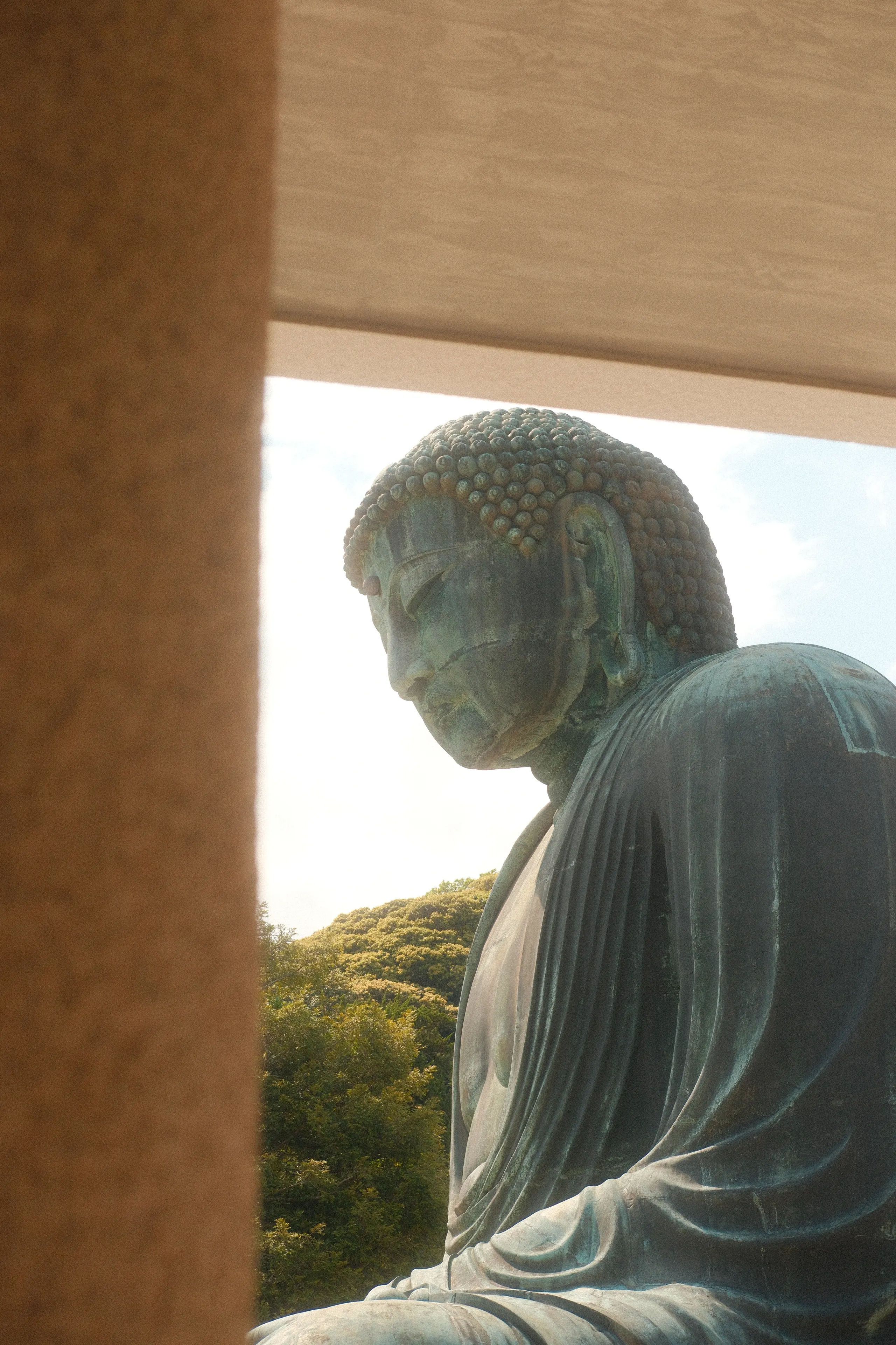 The Great Buddha's profile framed by a temple post