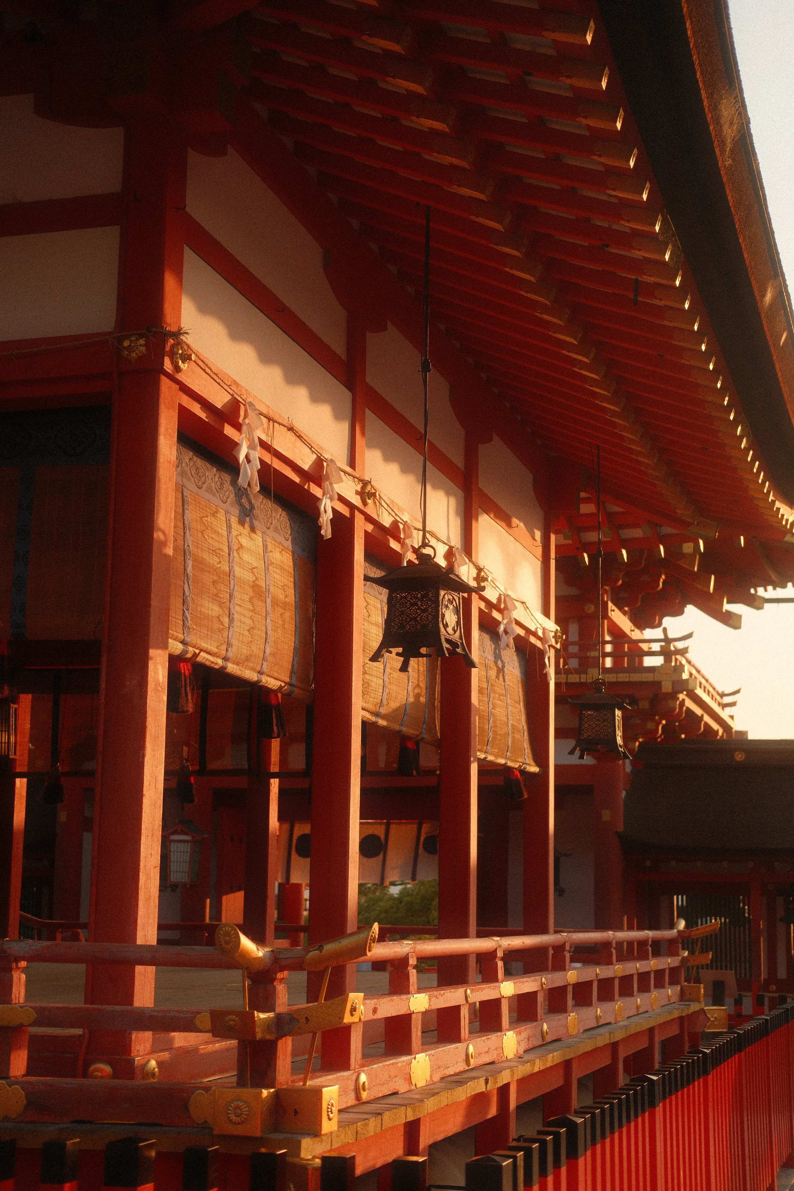 Red columns and hanging lanterns along a shrine hall in Kyoto