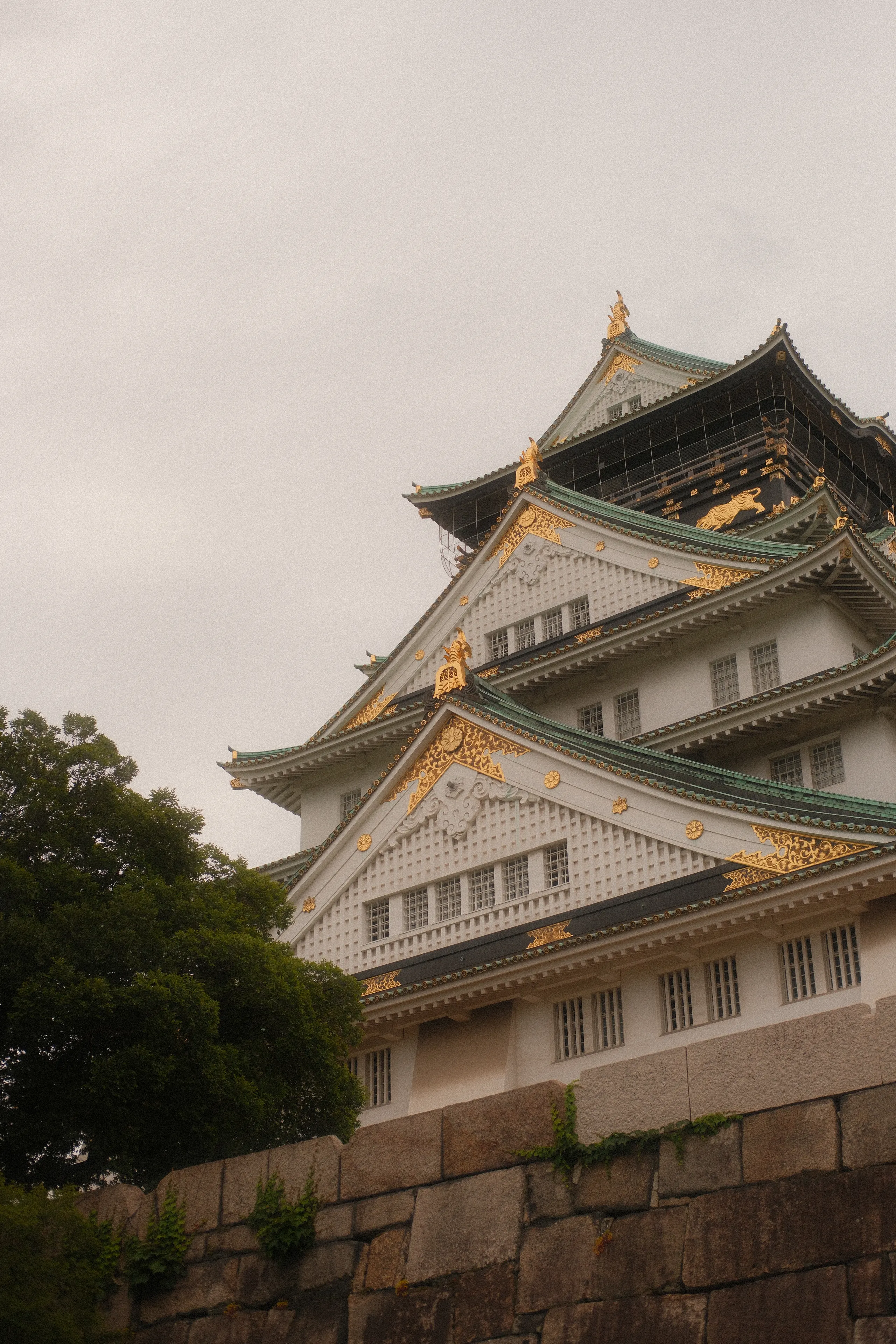 Osaka Castle rising above its stone walls on a grey day