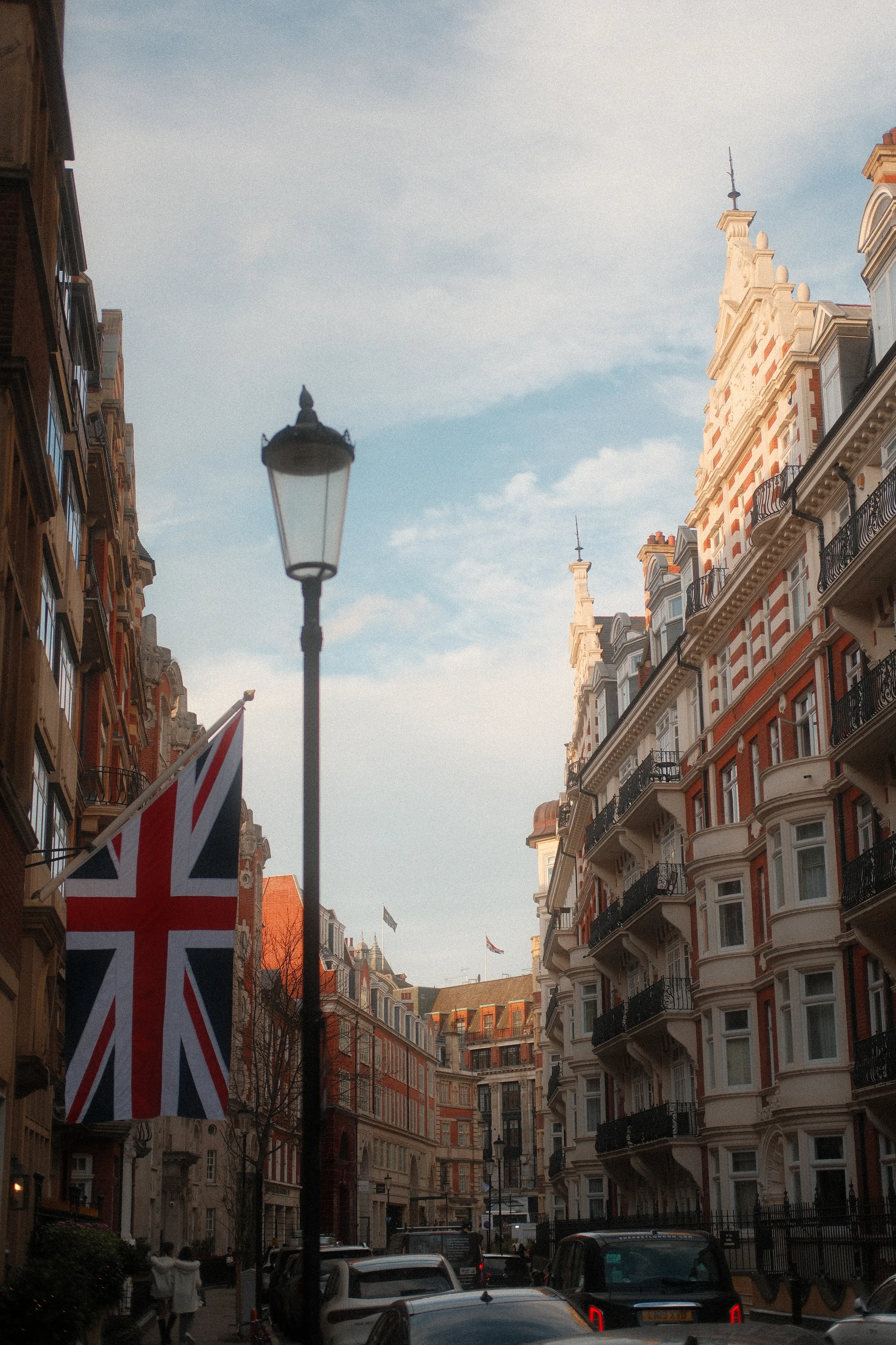 A Union Jack hanging over a red-brick London street