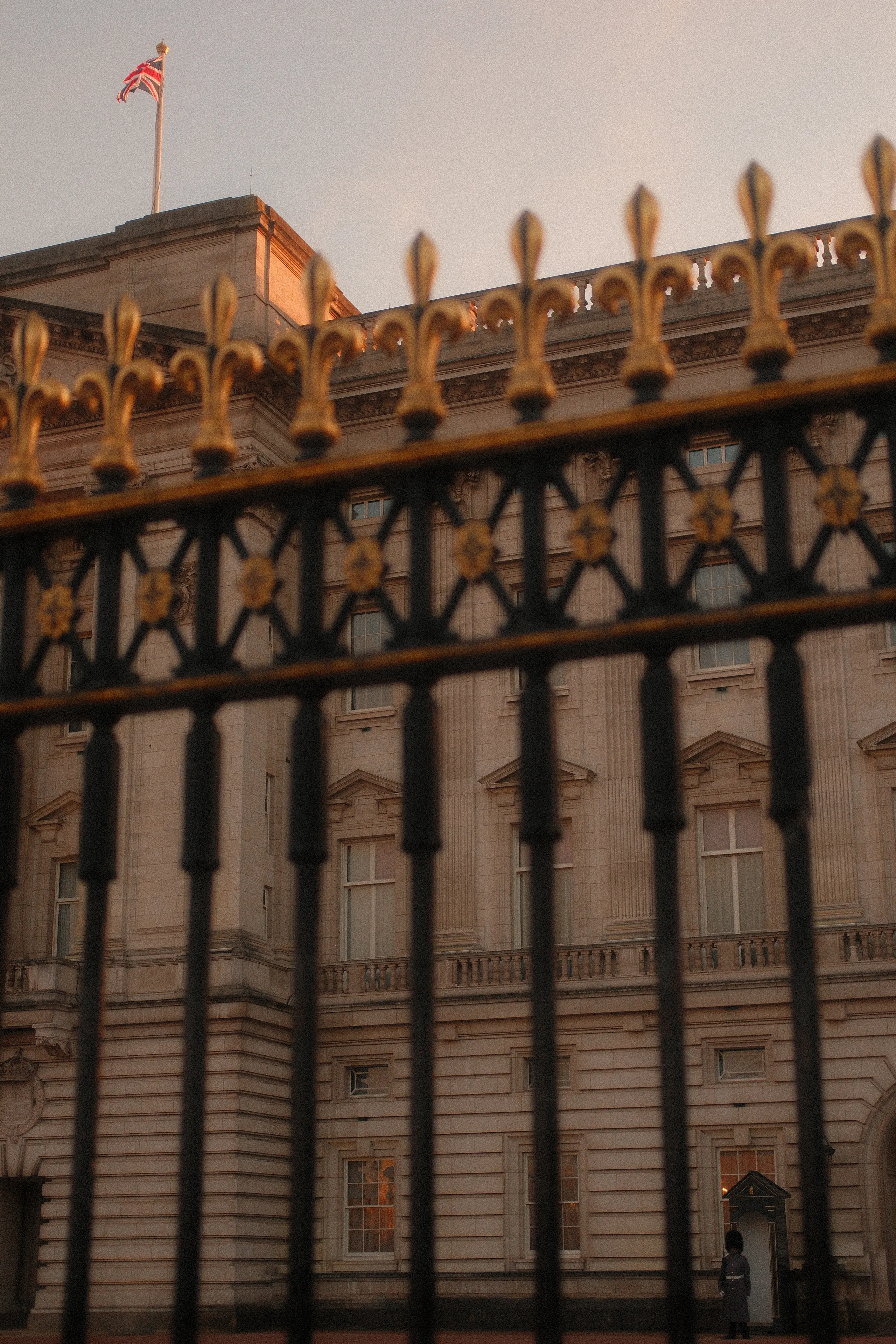 Gilded iron gates in front of a stone palace