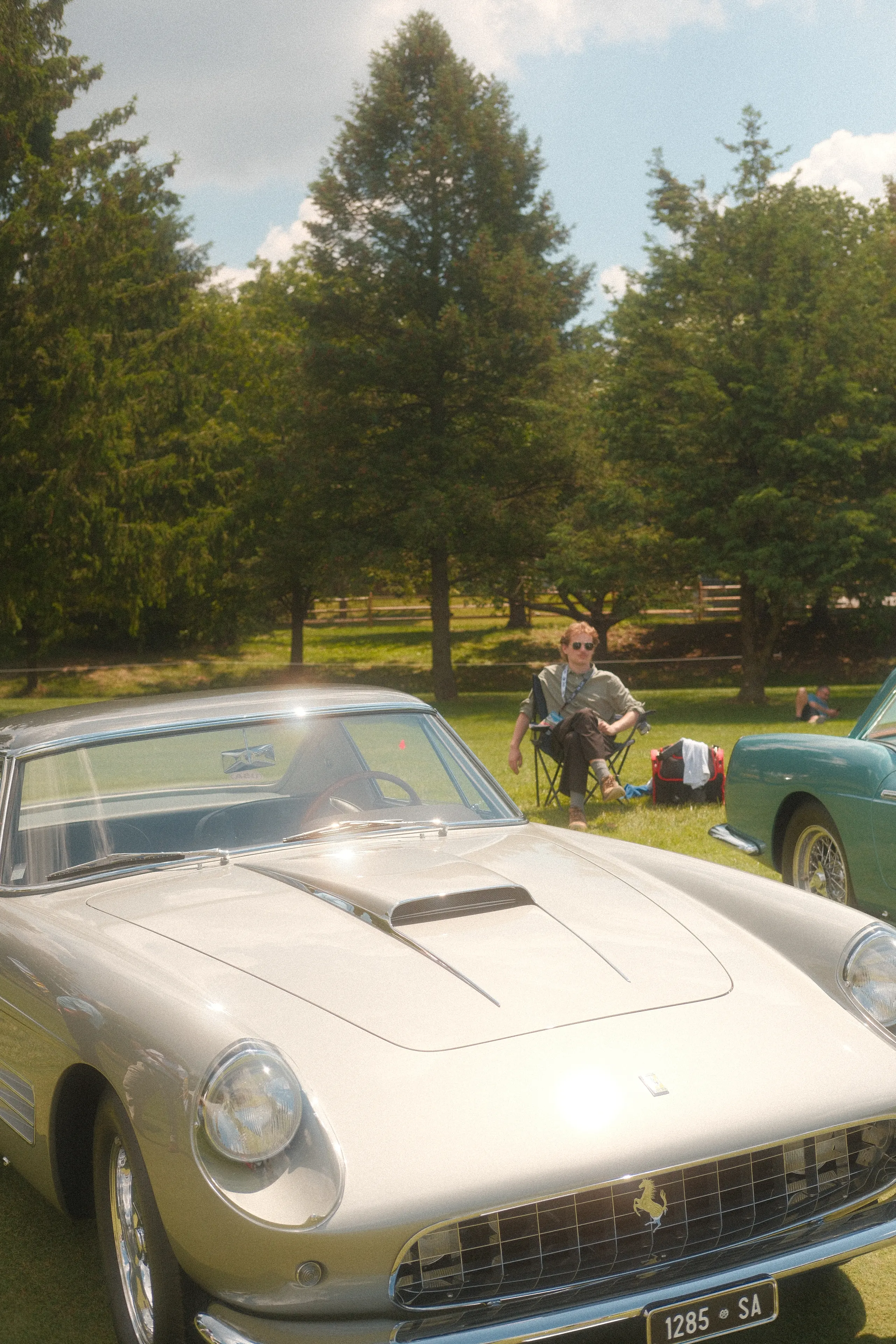 A silver Ferrari coupe parked on the grass