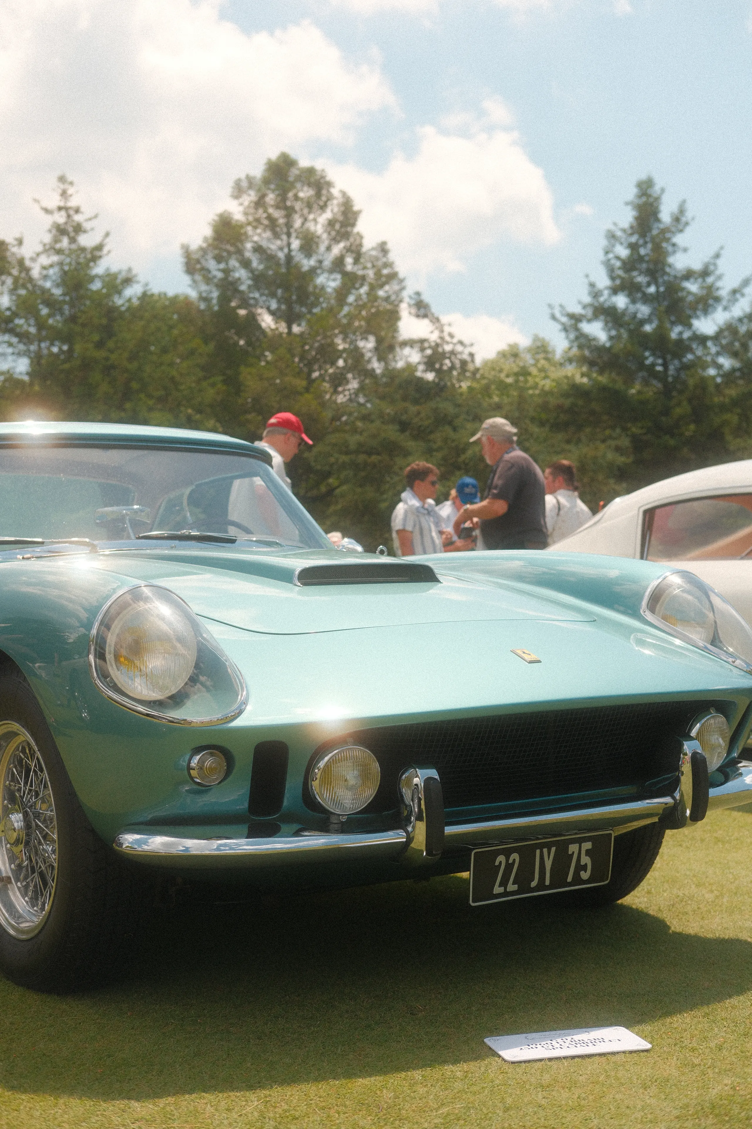 A teal Ferrari coupe with wire wheels