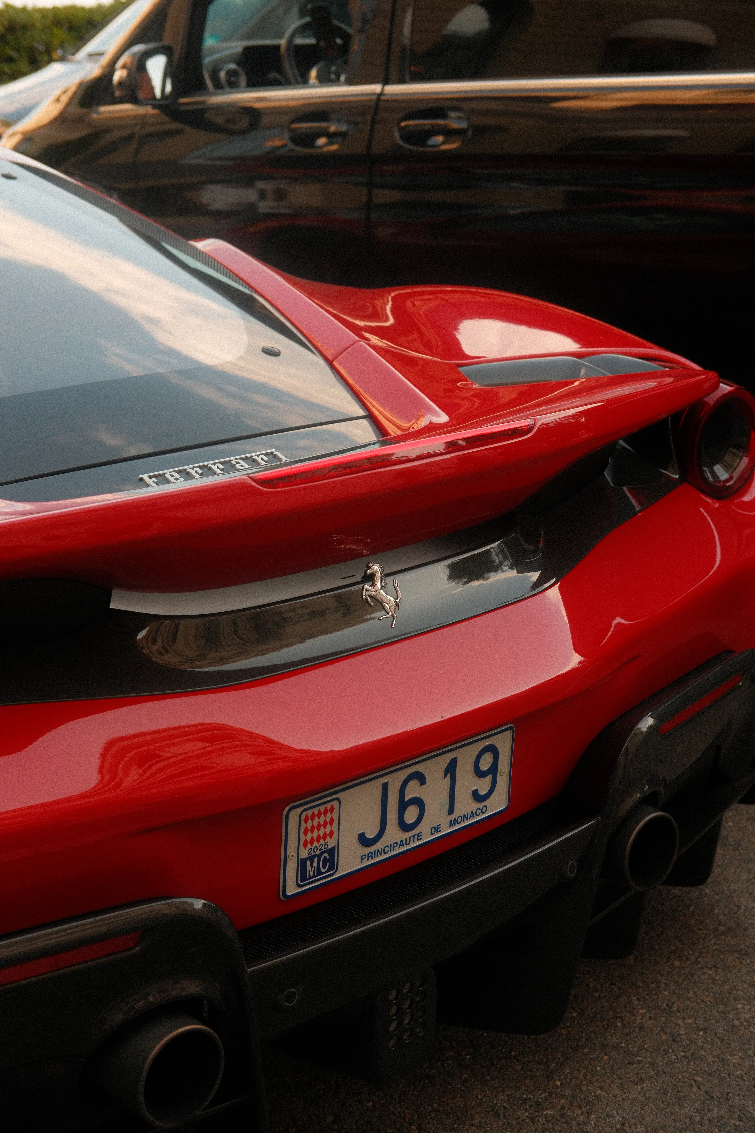 The rear of a red Ferrari with Monaco plates